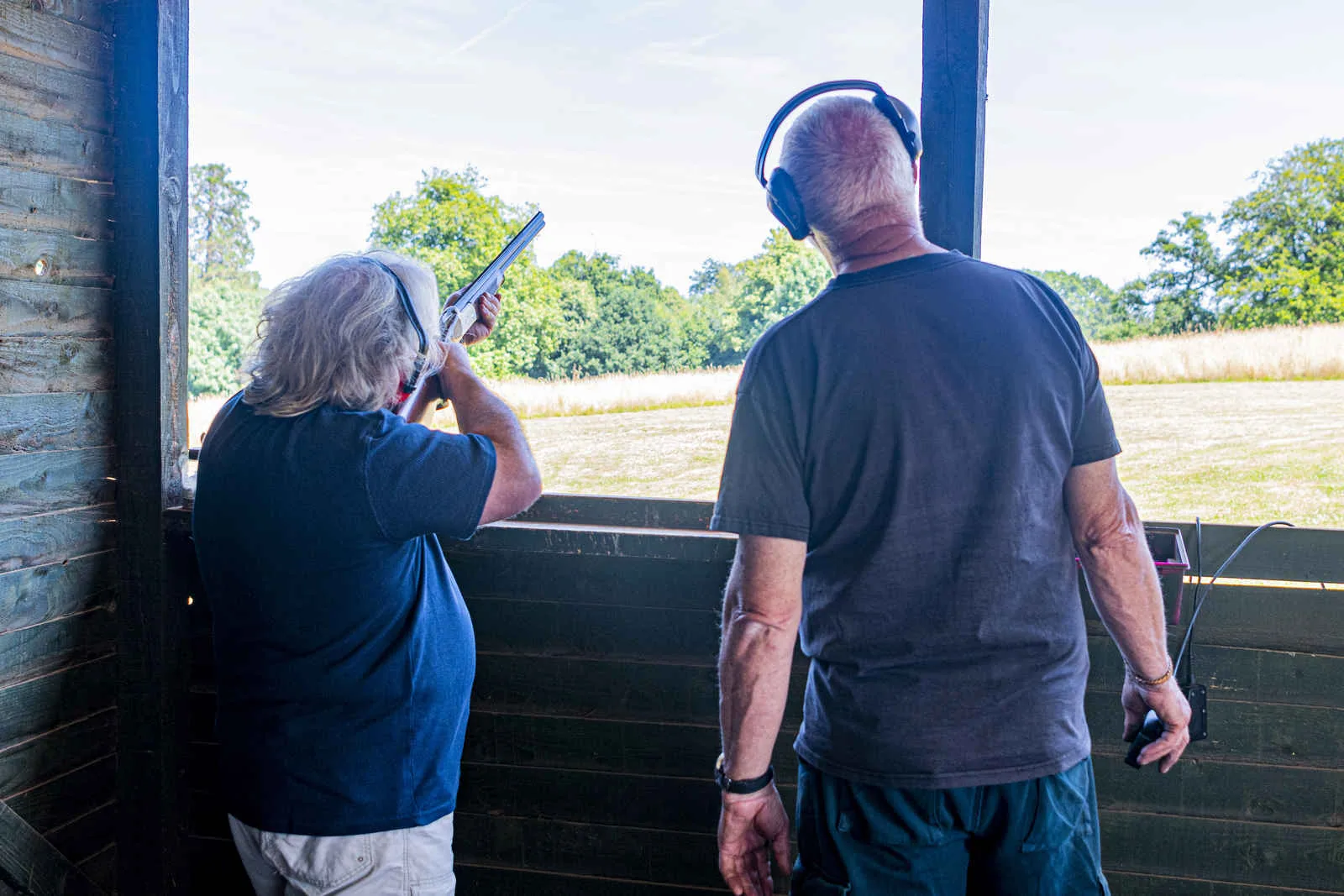 A clay shooting guest with an instructor at the covered shooting stand